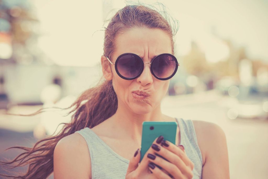 Closeup portrait upset sad, skeptical, unhappy, serious woman talking texting on phone displeased with conversation isolated outdoor background. Negative human emotion facial expression. Bad news