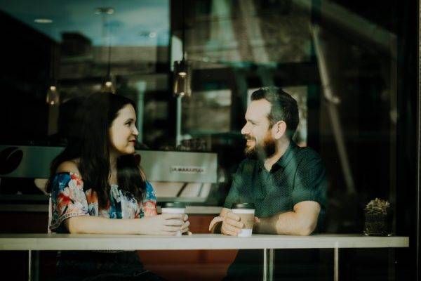 two people talk in a coffee shop