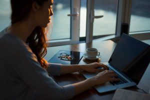 photo of woman writing on laptop