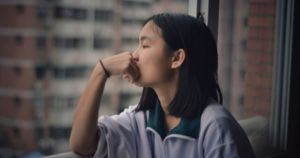 young woman looking out the window feature