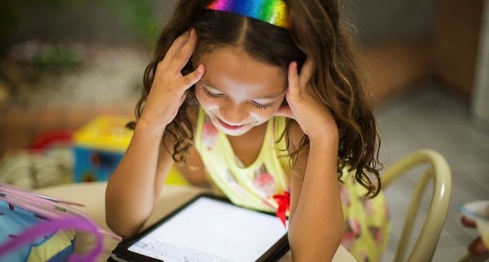 image of young girl reading on a tablet computer