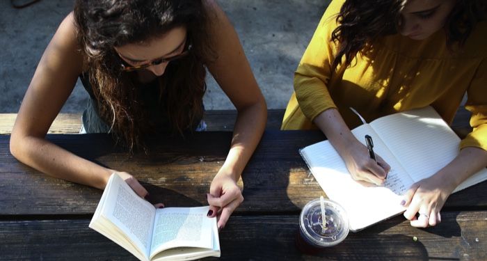 Image of people reading books outside together