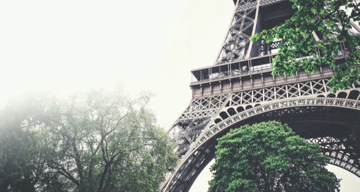 a section of the Eiffel Tower on a foggy day seen from a low angle