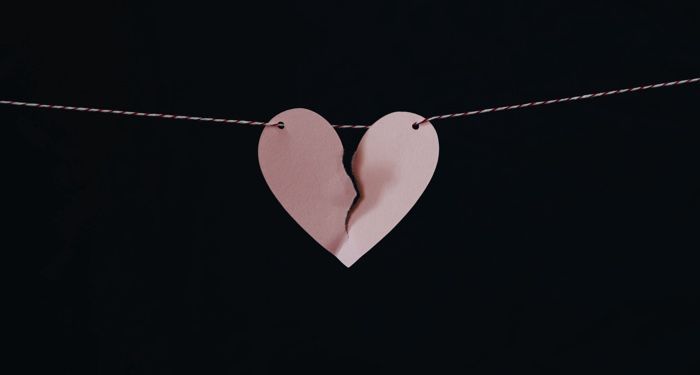 a pink paper broken heart hanging on a string