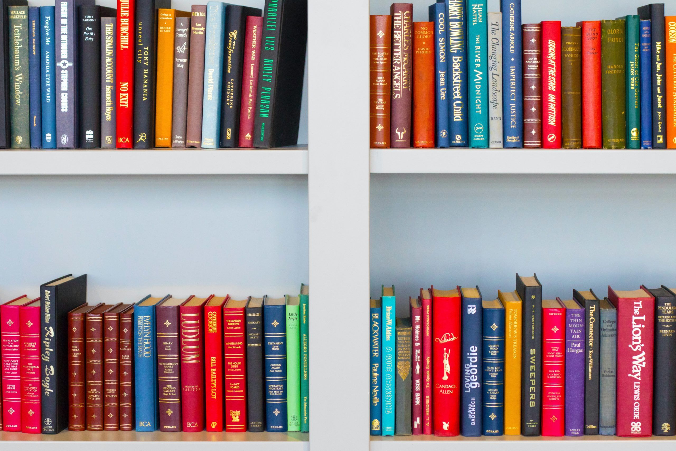 Colorful books on white shelves.