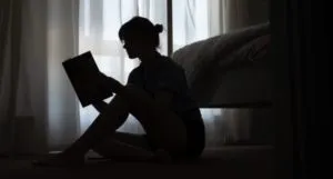 woman reading a book in the dark