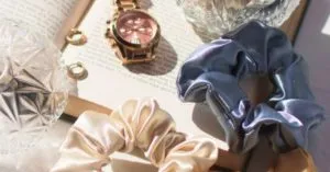 1990s satin scrunchies and rose gold watch on top of a book
