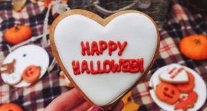 cookie with Happy Halloween in icing and Halloween and pumpkin cookies in background