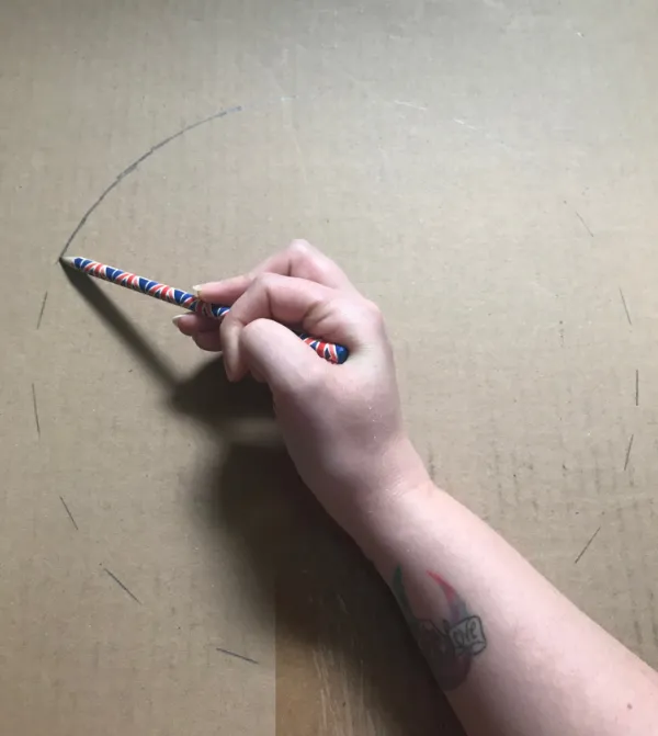 A picture of a hand holding a pencil, drawing a circle