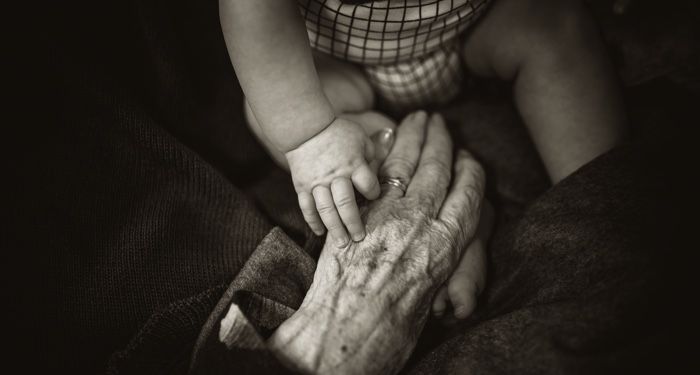 baby hand on top of older persons hand