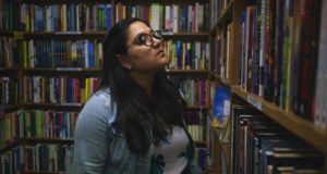 woman browsing books in bookstore or library