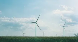 wind vanes above a grass field against blue sky