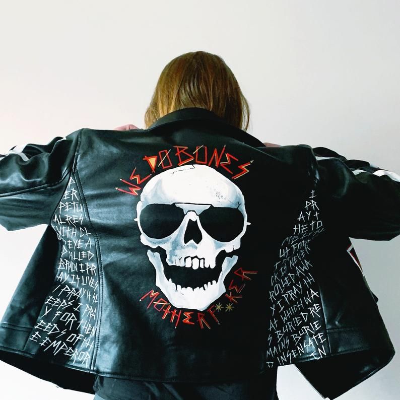 A faux leather jacket painted with a skull and quotations from Gideon the Ninth