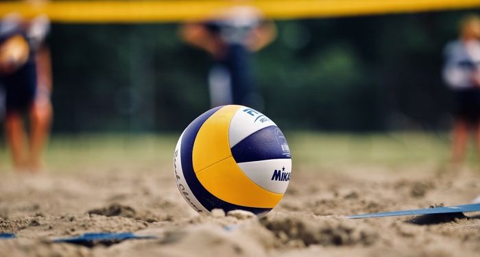 volleyball on sand with players in the distance for sports