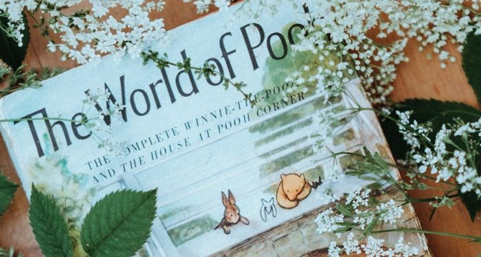 winnie the pooh book surrounded by white flowers