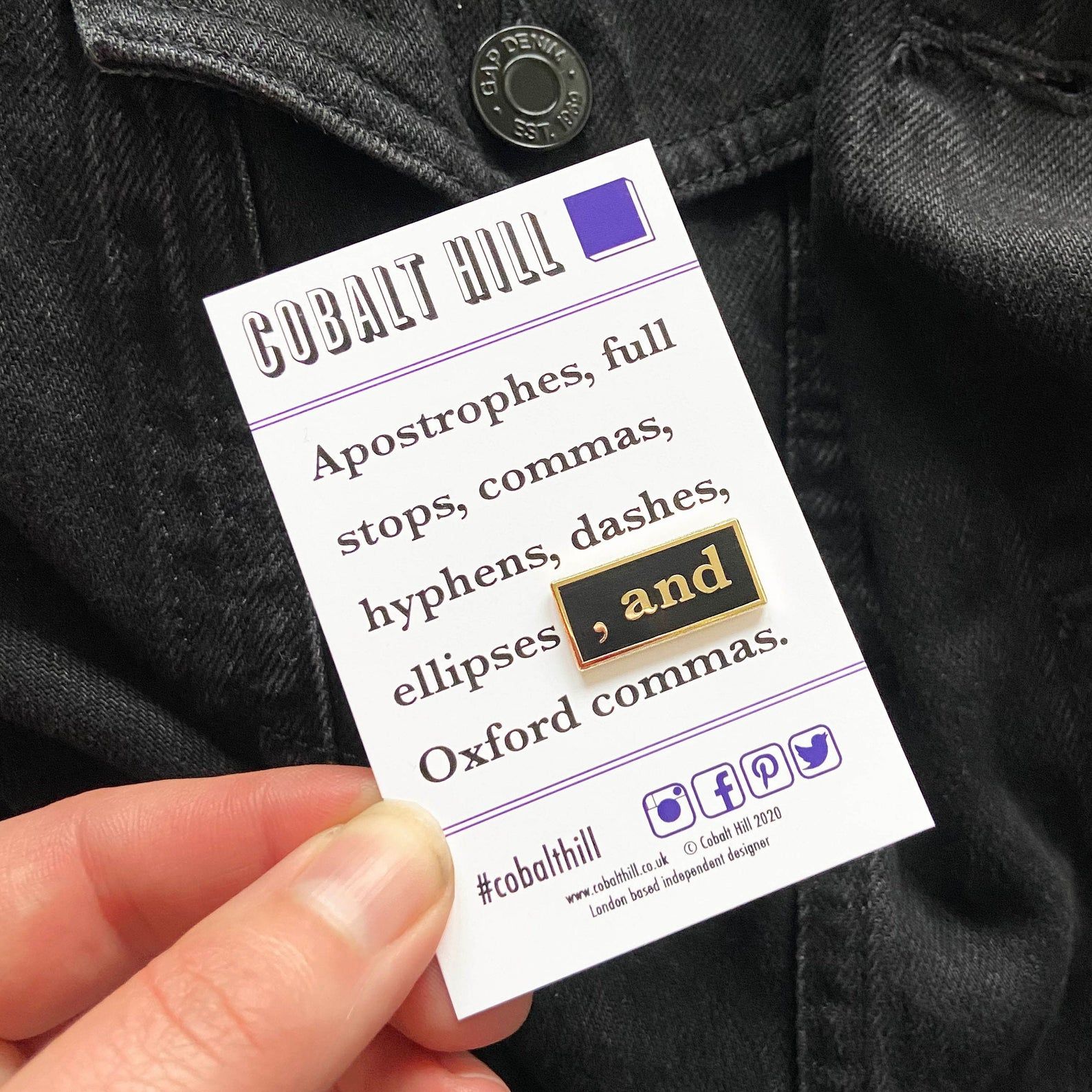 The pin reads " , and". It is on a cardboard backing that reads "Cobalt Hill: Apostrophes, full stops, commas, hyphens, dashes, ellipses, and Oxford commas." 