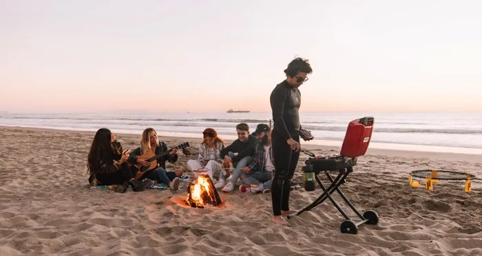teenagers on the beach with a bonfire and music