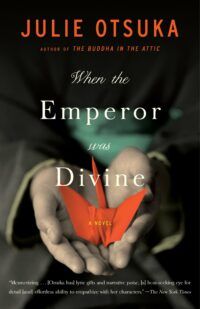 Book cover for When the Emperor was Divine, showing the author's name in orange text over a dark background. Behind the title text, two small hands hold an orange origami crane.