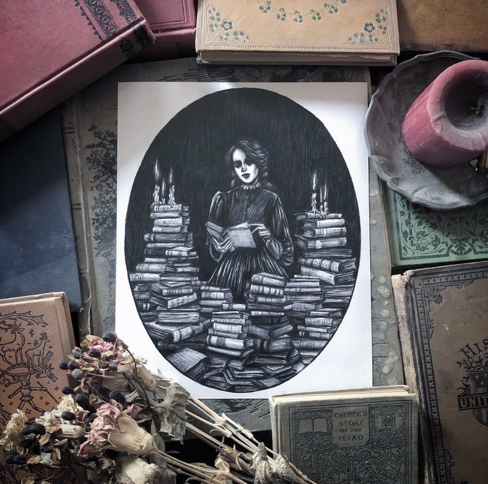 Black and white image of a girl surrounded by books.