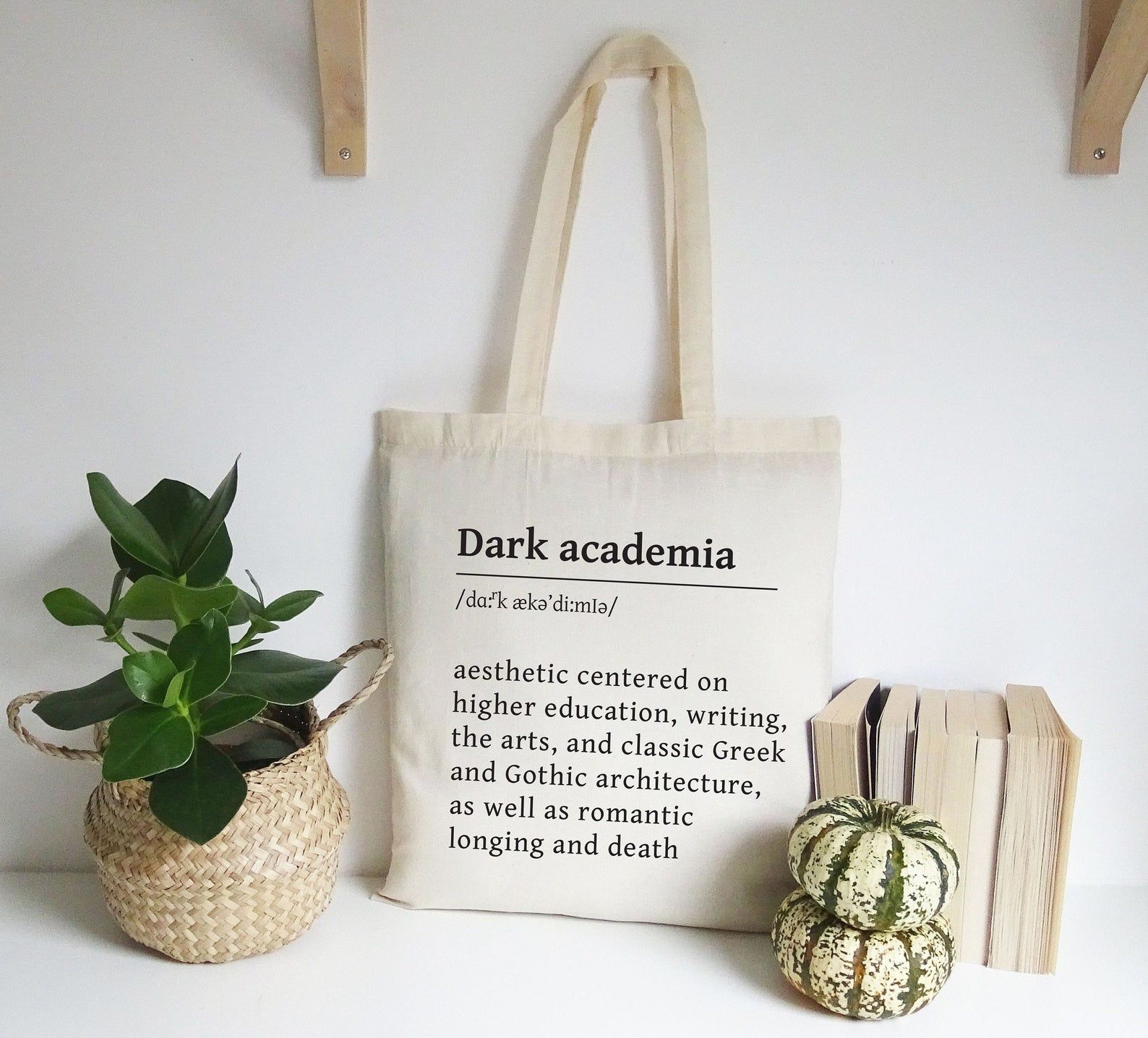 Image of a cream colored tote defining "Dark academia." 