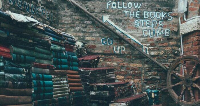 pile of books beside ship's wheel