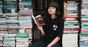 Asian woman reading surrounded by books at bookstore