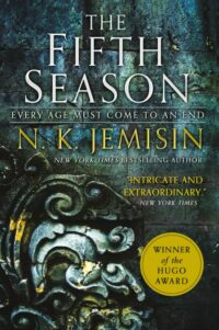 Book Cover for The Fifth Season, showing the title in white over a green-blue stone background. In the bottom left corner is some filigree style stonework.