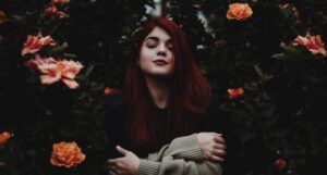 red headed girl around flowers