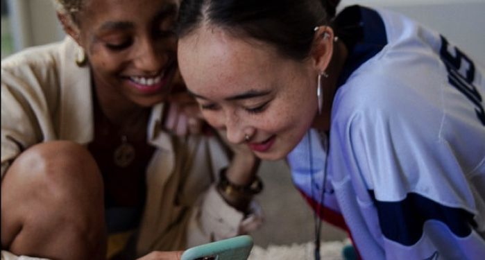 image of women looking at phone and smiling
