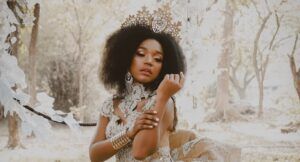 a photo of a Black woman wearing a crown in a wintry forest