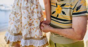 grandmother holding granddaughter's hand while walking