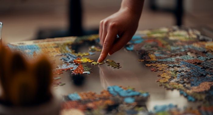 Image of a hand putting together a puzzle