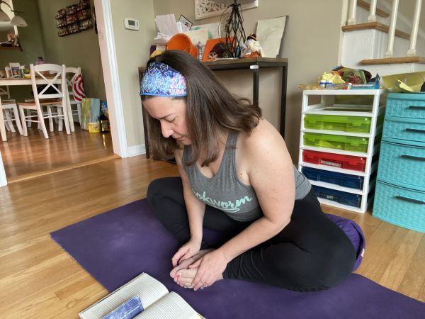 author reading while in baddha konasana