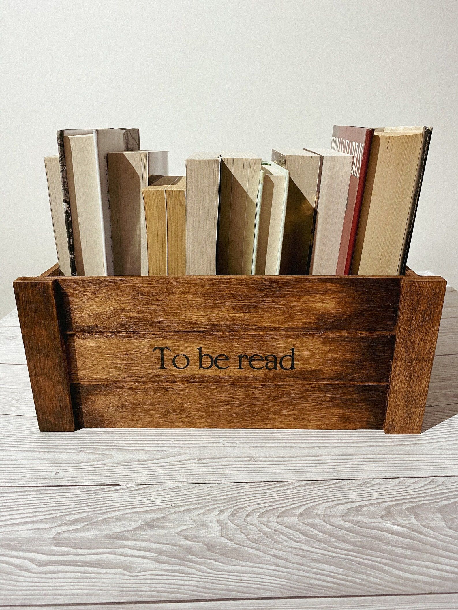 wooden crate holding books that says to be read on the front 