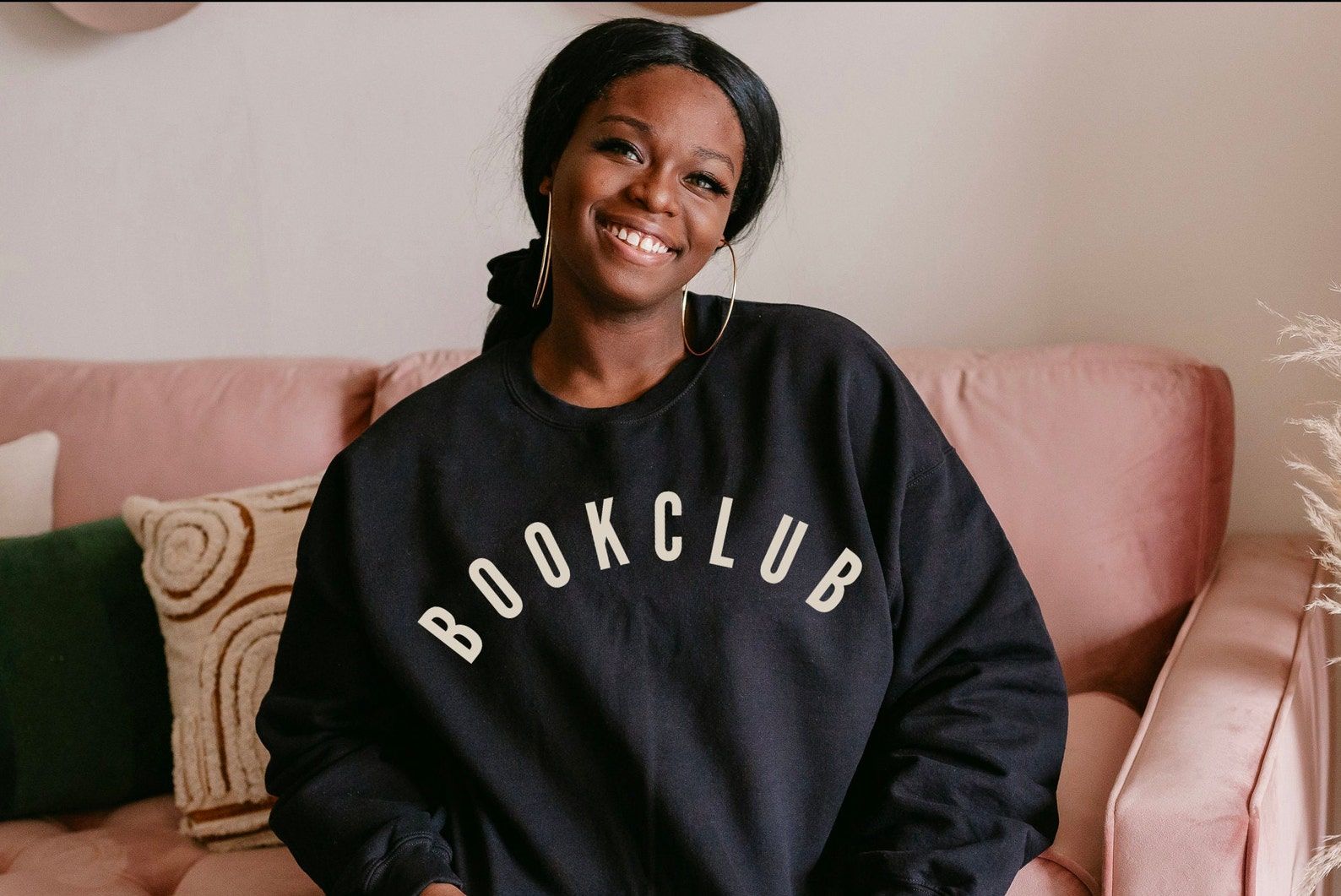 Image of a Black woman wearing a black sweatshirt. The white font reads "book club."