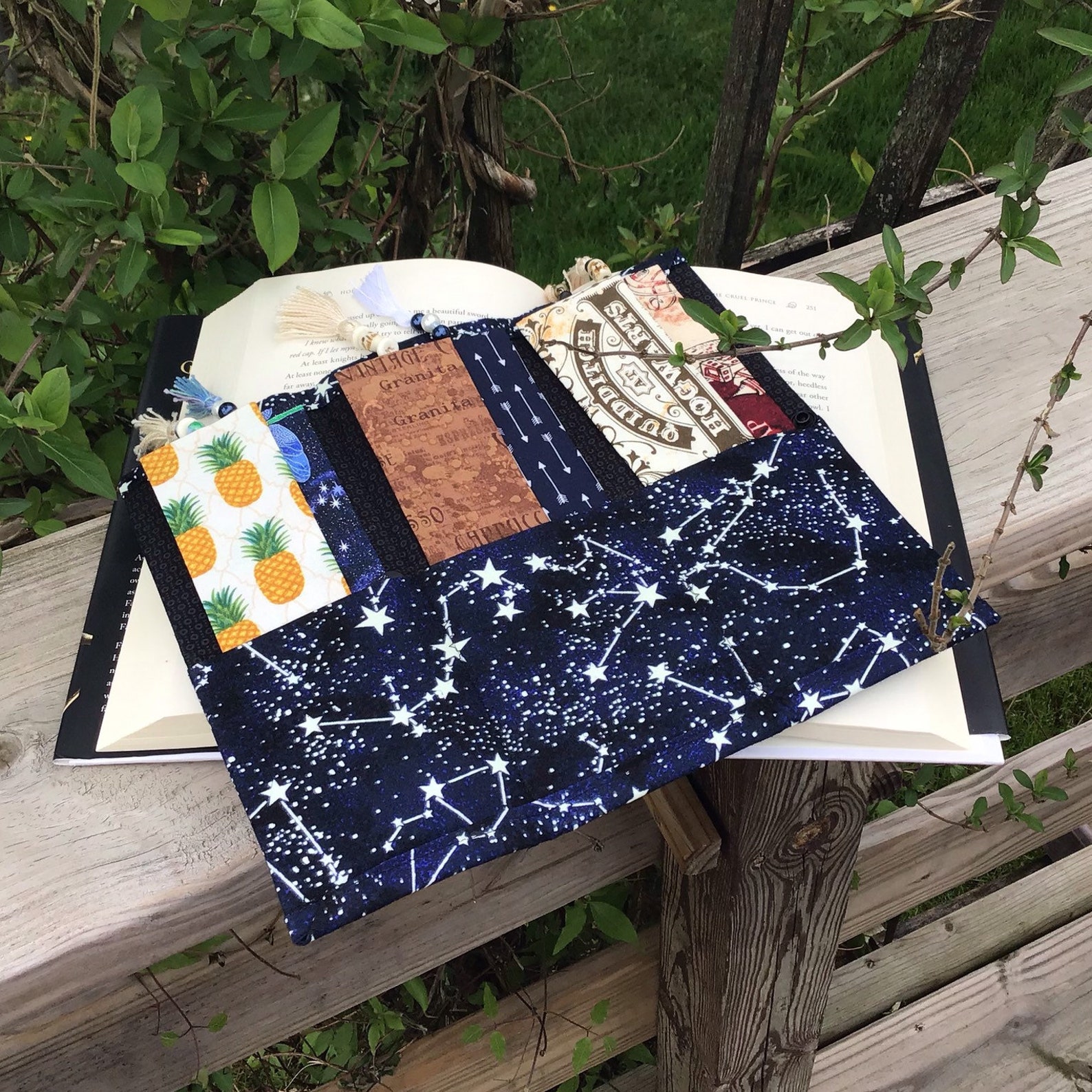 A cloth organizer with three pockets for bookmarks, in a constellation print.
