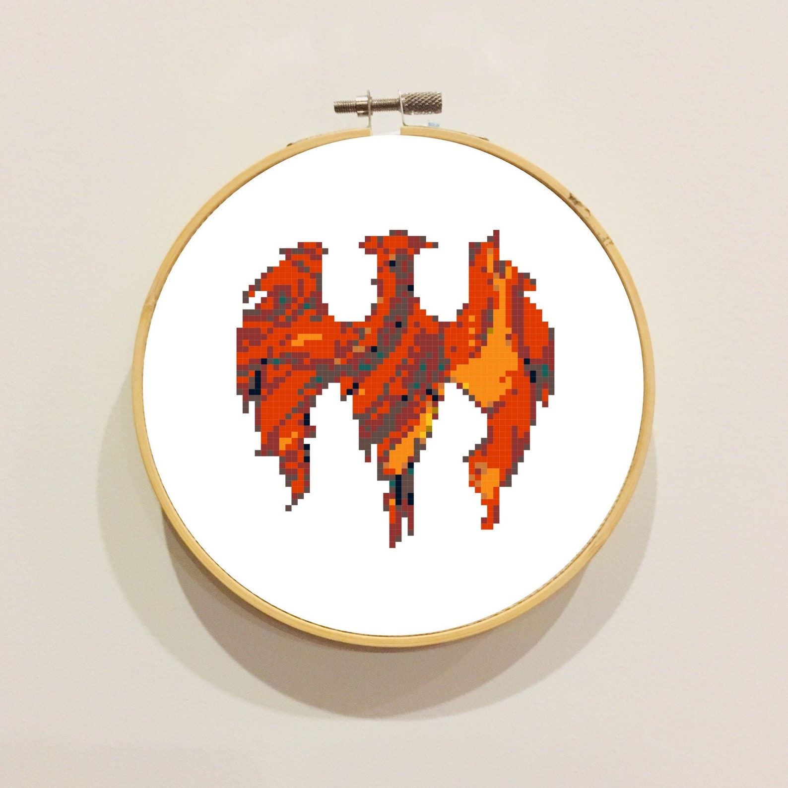 circular hoop featuring a firebird cross stitch