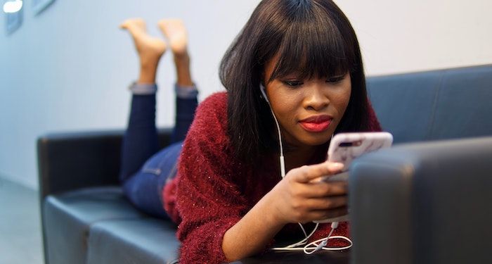 image of a Black woman reading on her phone