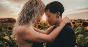 two women cuddling in a sunflower field