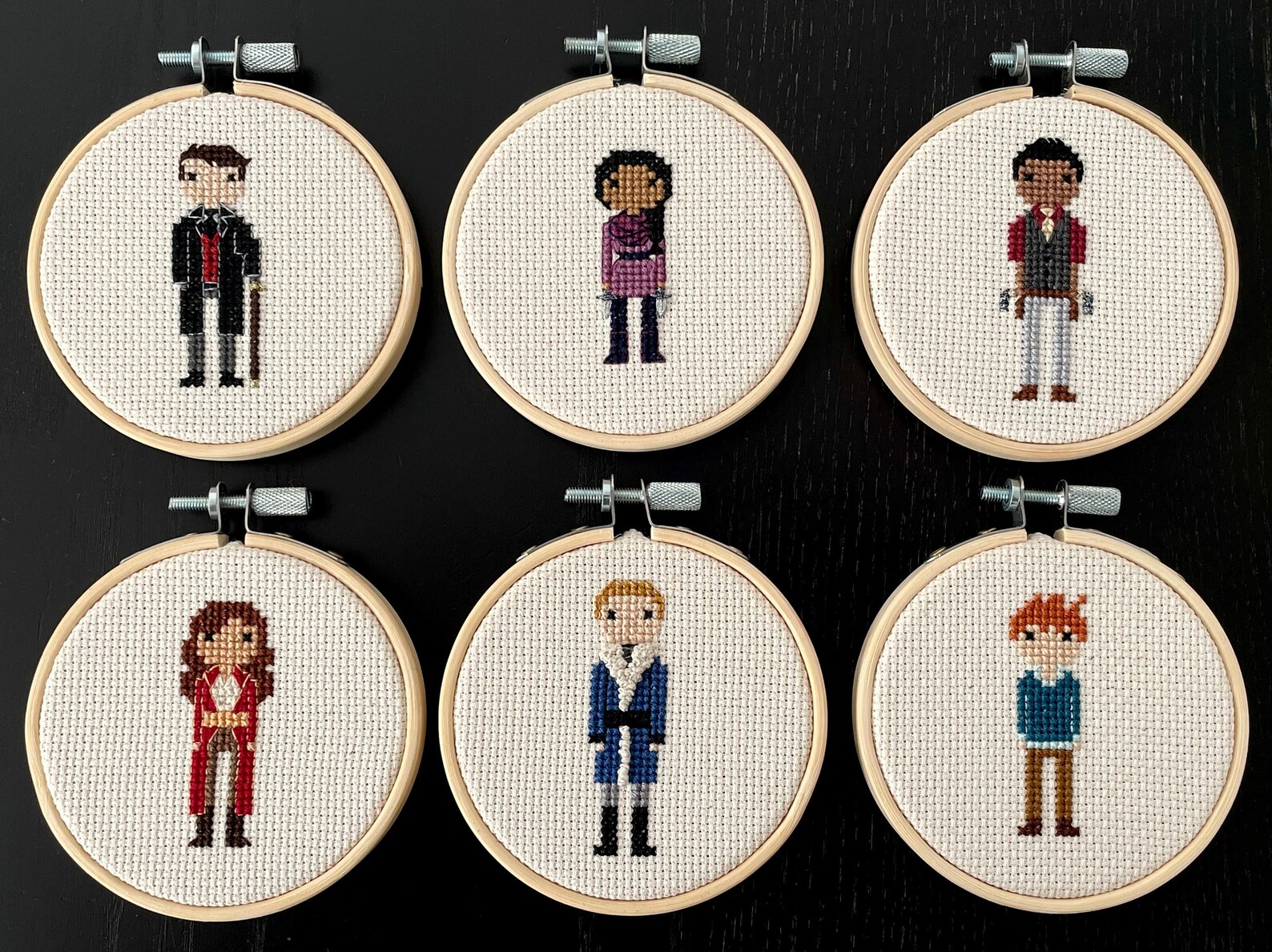 six small circular hoops each displaying a different character from Six of Crows