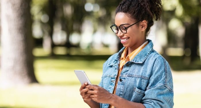 image of a young Black person reading on a phone.