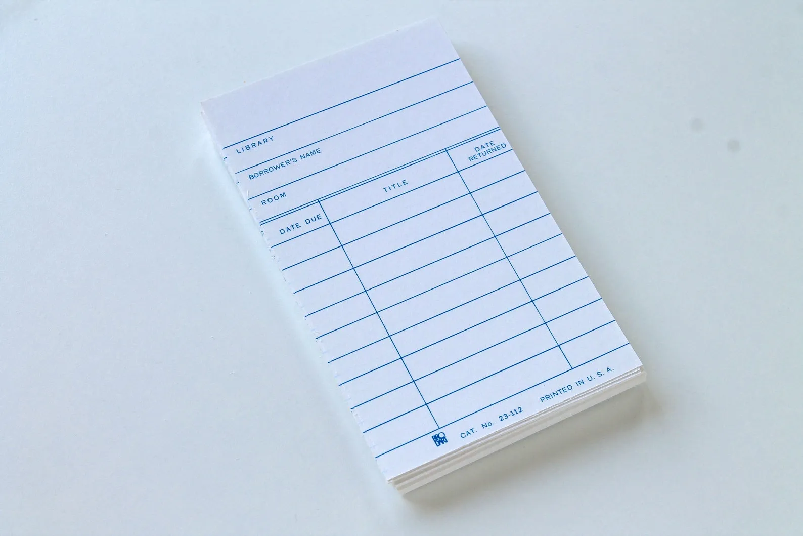 Image of a stack of white library due date cards. 
