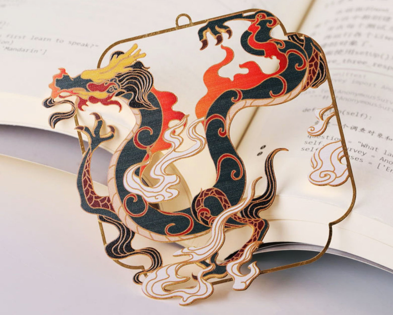 Image of a dragon bookmark. The main colors are black, red, and yellow. 
