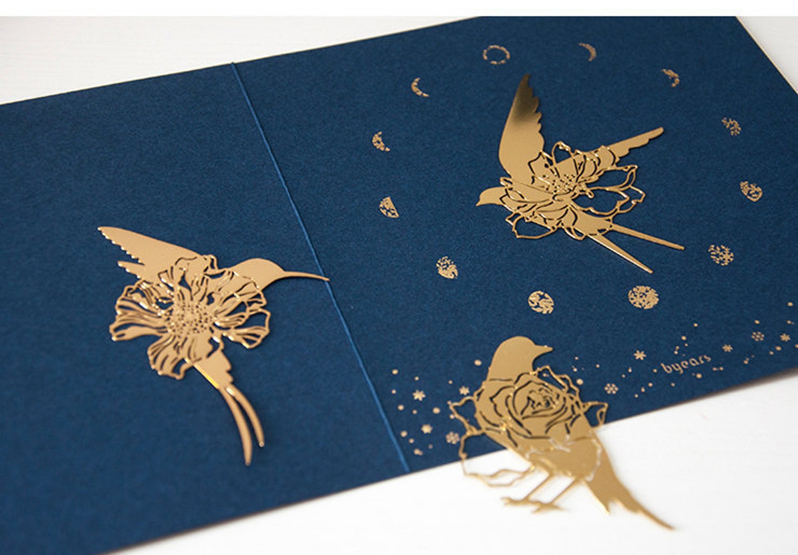 Image of three metal bird bookmarks, including a hummingbird and a swallow. 