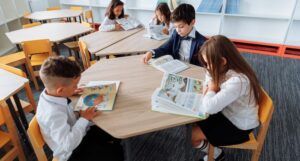 children reading at tables in a library