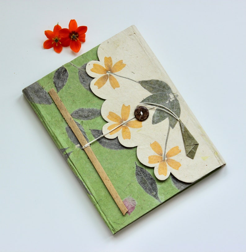 Image of an intricately-designed green notebook made by hand. 