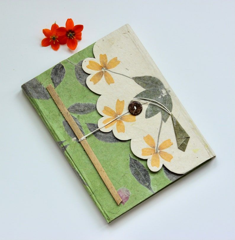 Image of an intricately-designed green notebook made by hand. 