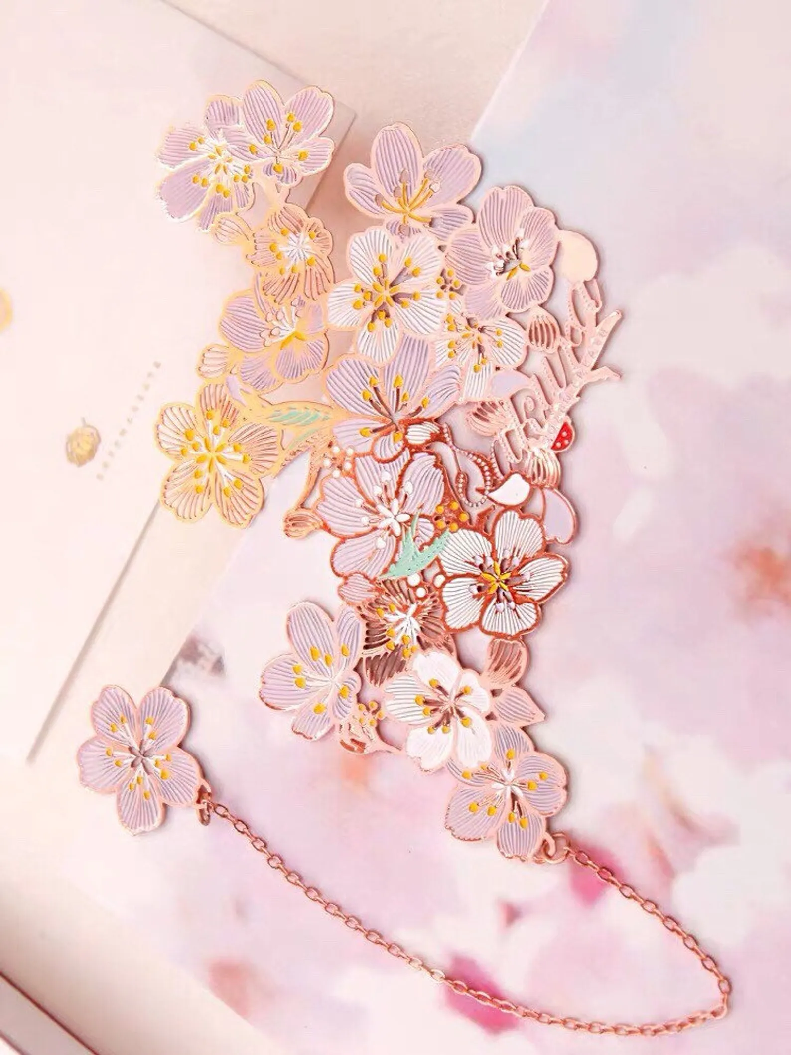 Image of an intricate rose gold plated sakura bookmrk.