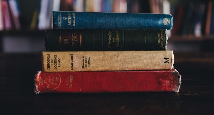 a stack of four old hardcover books