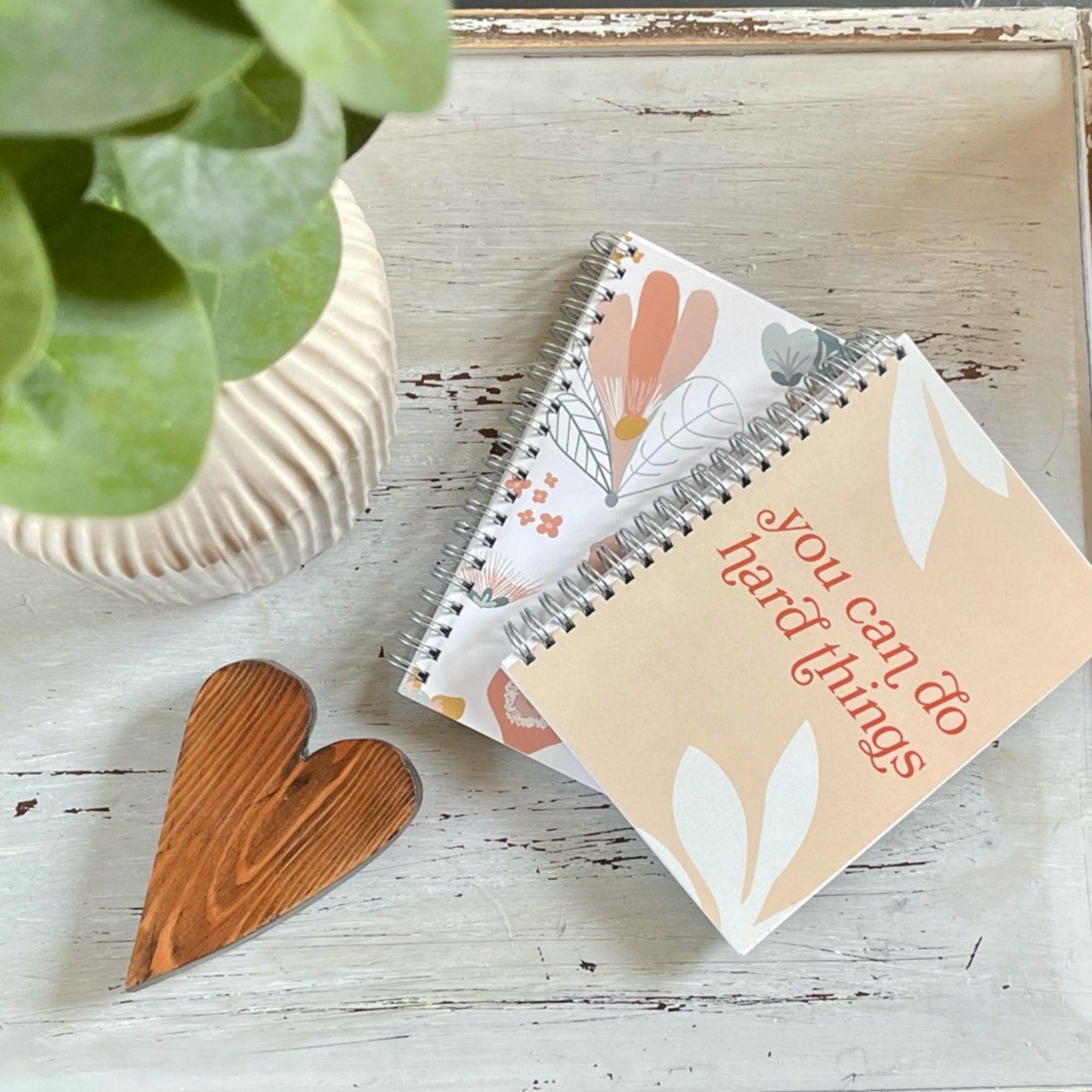 image of two notebooks on a white background. the top notebook reads "you can do hard things" on a light  orange background. 